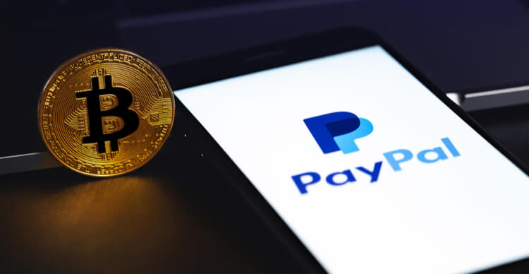 Bild der PayPal-App auf einem Smartphone neben einem Bitcoin